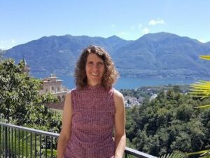 Happy lady on sunny balcony overlooking lush valley