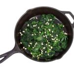 Photo of sauteed spinach and pine nuts in skillet from "Sauteed Garlic and Spinach" recipe from Green Smoothie Girl