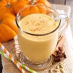 Photo of pumpkin pie smoothie in glass with cinnamon and mini pumpkins surrounding from "Pumpkin Pie Smoothie" recipe by GreenSmoothieGirl