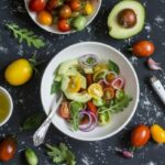 Photo of tomatoes, avocados, greens in bowl from "Avocado Almond Salad" recipe by Green Smoothie Girl