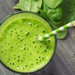 Photo of topdown view of green smoothie with green striped paper straw in it and spinach surrounding from "{VIDEO} Why Are You Afraid of Detoxing?" by Green Smoothie Girl