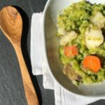 Photo of split pea soup in white bowl and wooden spoon from "My Famous Split Pea Soup" recipe by Green Smoothie Girl