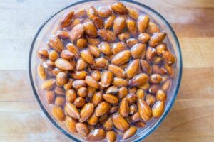 Photo of bowl of soaking almonds from "13 Top Raw Almonds Nutrition Benefits (And How To Get Truly Raw Almonds)" by Green Smoothie Girl