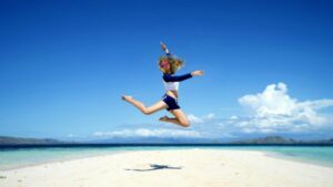 Photo of woman jumping energetically on the beach from "13 Top Raw Almonds Nutrition Benefits (And How To Get Truly Raw Almonds)" by Green Smoothie Girl