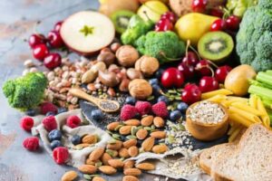 Photo of fruits, vegetables, and nuts spilling on table from "What Are Probiotics Benefits? 11 Signs You’re Deficient And What To Do About It" by Green Smoothie Girl