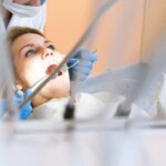Photo of woman with mouth open and dentist with surgical tools from "What Happened When My Root-Canal Teeth Were Pulled" by Green Smoothie Girl