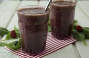 Photograph of two smoothies in glasses on a striped tablecloth, from "9 Ways to Get Kids to Drink Healthy Green Smoothies" at Green Smoothie Girl.