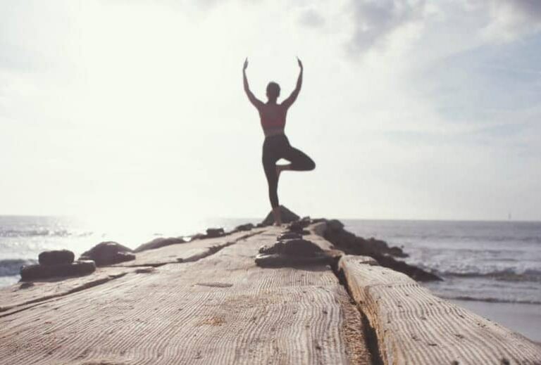 Photo of person doing yoga tree pose in background from "14 Ways I Optimize My Health And Energy Every Day" by Green Smoothie Girl