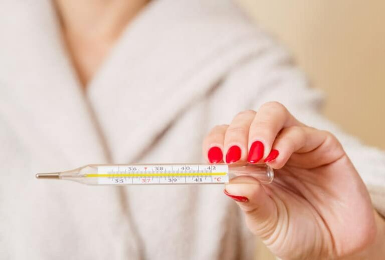 Close-up image of a woman holding a thermometer, from "Hyperthermia Treatment: Effective, or All Hype?" at Green Smoothie Girl.