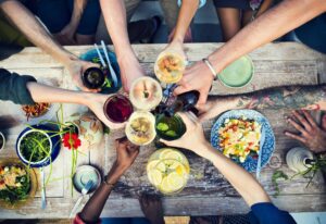 A group of friends makes a toast before eating together. From "How to Use a Tongue Scraper (And Why You Should Make it a Habit)" at Green Smoothie Girl.