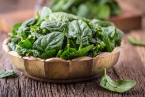 Image of raw spinach leaves in a bowl, from "How To Freeze Spinach and Other Leafy Greens For Later (With Shortcuts!)" at Green Smoothie Girl.