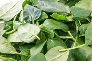 Photograph of a pile of green spinach leaves, from "11 Greens to Use in Green Smoothies" at Green Smoothie Girl.