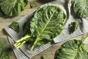 Photograph of raw collard greens on a striped tablecloth, from "Top 11 Greens to Use in Green Smoothies" at Green Smoothie Girl.