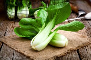 Photograph of bok choy on a burlap cloth and wood table, from "Top 11 Greens to Use in Green Smoothies" at Green Smoothie Girl.