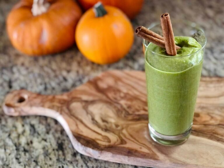 photo of a green smoothie with two cinnamon sticks in it with pumpkins in the background from Green Smoothie Girls's "green pumpkin smoothie"