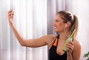 Photograph of a woman taking a selfie with her green smoothie, from “Why You Should Chew Your Green Smoothies” at Green Smoothie Girl.