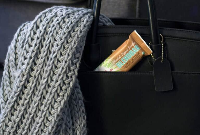 Photo of chocolate green smoothie girl blend bar in black purse pocket from "Why Most Nutrition Bars are Garbage -- and What to Pack in Your Purse Instead" at Green Smoothie Girl