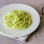 pasta with pesto sauce in a bowl with silverware