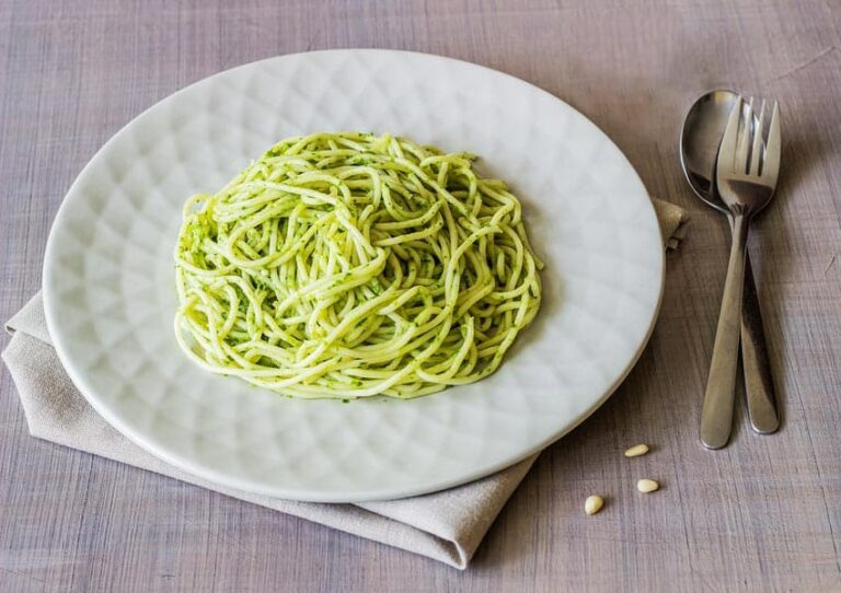pasta with pesto sauce in a bowl with silverware