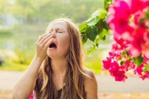 Photo of woman sneezing from "19 Natural Remedies to Relieve Seasonal Allergies" at Green Smoothie Girl.