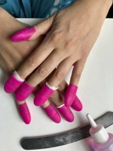 Photo of a woman using nail polish remover from "Can Nail Polish Be Healthy? Don’t Paint Your Nails Again Without Reading This!" at Green Smoothie Girl.