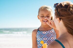 Photo of woman putting sunscreen on child from "Sun Exposure, Sunburn Prevention, & 5 Effective Natural Sunburn Treatments" at Green Smoothie Girl.