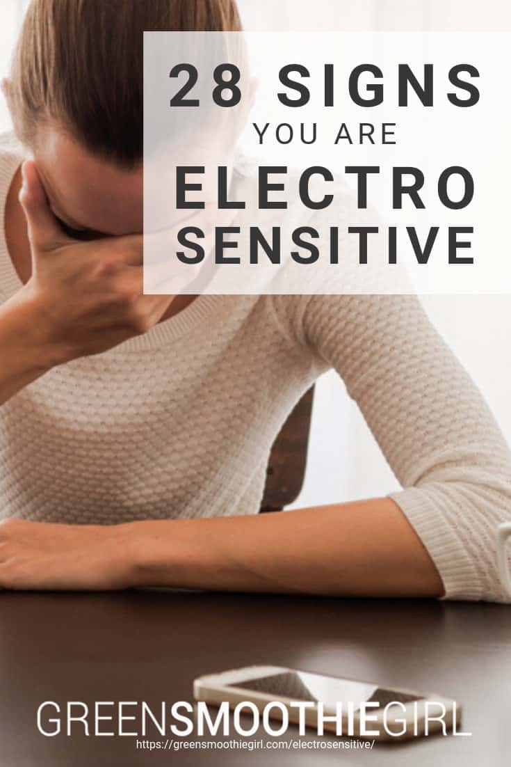 Photo of woman holding her forehead in her hand and cellphone on the table with post's title text overlaid from "28 Signs That You Are Electrosensitive" by Green Smoothie Girl