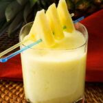 Photo of yellow pineapple smoothie with slices on top from "Summer Surprise Green Smoothie" recipe by Green Smoothie Girl
