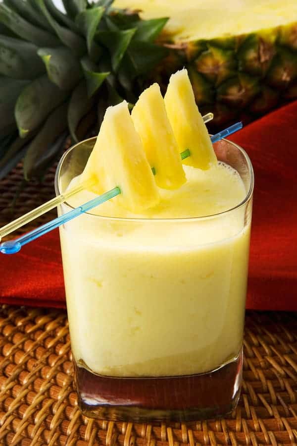 Photo of yellow pineapple smoothie with slices on top from "Summer Surprise Green Smoothie" recipe by Green Smoothie Girl