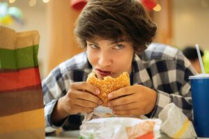 Photo of teenager eating fast food from "How To Fight Depression and Anxiety: 10 Nutrition Strategies" at Green Smoothie Girl.