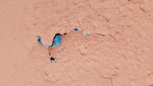 Photo of pink cracked paint with blue underneath from "What To Do About Toxic Paint, Carpet, Furniture (Offgassing For Years!)" by Green Smoothie Girl