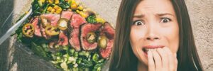 Photo of person biting fingernails nervously with meat platter in background, from "Why Ketosis Diets Will Fail: The Paleo and Keto Manifesto" at Green Smoothie Girl