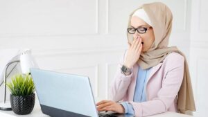 Photo of Muslim woman yawning at desk from "no energy? fatigue causes you haven't considered" blog post by Green Smoothie Girl