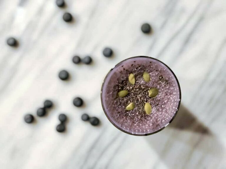 Photo of top-view purple smoothie with blueberries on a marble counter from "Power Green Smoothie" recipe by Green Smoothie Girl