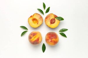 Photo of four peach halves in square formation with pits in from "Mums’ Magical Antiviral Hot LemonAid Tonic" by Green Smoothie Girl