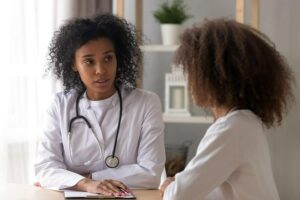 Photo of African American doctor consulting her patient from "How To Recover From The Side Effects Of Prednisone And Other Corticosteroids" by Green Smoothie Girl