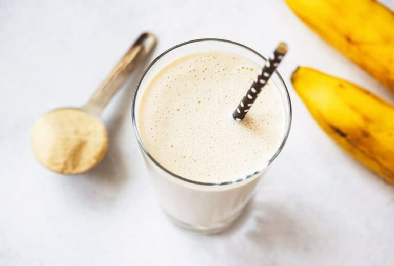 Photo of vanilla smoothie with straw and scoop of protein from "Modified Fasting 101: The Ultimate Beginner’s Guide" by Green Smoothie Girl