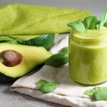 Photo of green smoothie with mint and straw apple and avocado on table from "Morning Mojito Smoothie" recipe by Green Smoothie Girl