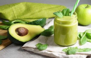 Photo of green smoothie with mint and straw apple and avocado on table from "Morning Mojito Smoothie" recipe by Green Smoothie Girl
