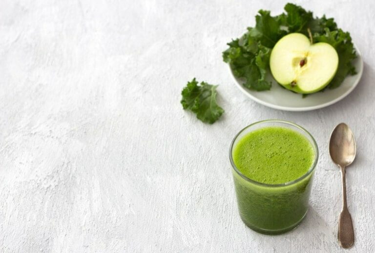 Photo of foamy green smoothie with apple and kale in background from How To Prevent UTI With Food: Green Smoothie Recipes For Urinary Tract Health" by Green Smoothie Girl