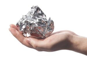 Photo of hand holding ball of aluminum foil from "Is Cooking With Aluminum Foil Safe? Why Researchers Say No"by Green Smoothie Girl