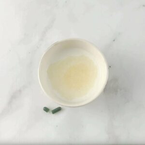 Photo of bowl of milk on marble counter with probiotic powder inside from "How to Test your Probiotic Supplement at Home"by Green Smoothie Girl