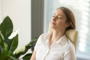 Photo of woman leaning back in chair with eyes closed and calm expression from "14 Ways I Optimize My Health And Energy Every Day" by Green Smoothie Girl