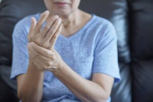 Photo of Japanese elder woman holding wrist in arthritis pain from "3-Day Water Fasting vs. 3-Day Modified Fasting" by Green Smoothie Girl