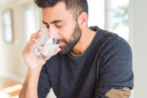 Photo of handsome man drinking clean water from "3-Day Water Fasting vs. 3-Day Modified Fasting" by Green Smoothie Girl