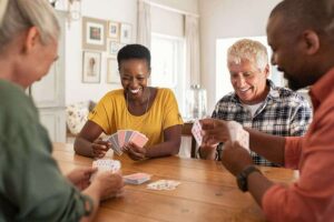 Photo of multiethnic mature friends playing cards from "14 Ways I Optimize My Health And Energy Every Day" by Green Smoothie Girl