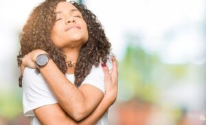 Photo of young woman with curly hair embracing herself with serene expression from "{VIDEO} Why Are You Afraid of Detoxing?" by Green Smoothie Girl