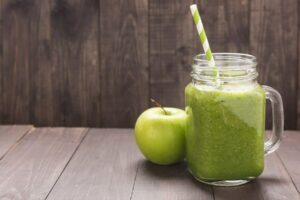 Photo of healthy green vegetables and green fruit smoothie on rustic wood table from "10 Green Smoothies For Seasonal Affective Disorder" by Green Smoothie Girl