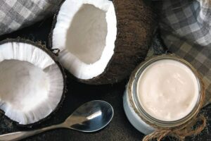 Photo of open coconut halves next to spoon and jar of coconut yogurt from "10 Green Smoothies For Seasonal Affective Disorder" by Green Smoothie Girl