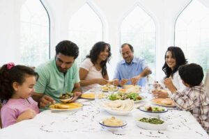 Photo of happy middle-eastern family eating dinner together from "The Truth About The OMAD (One Meal a Day) Diet" by Green Smoothie Girl